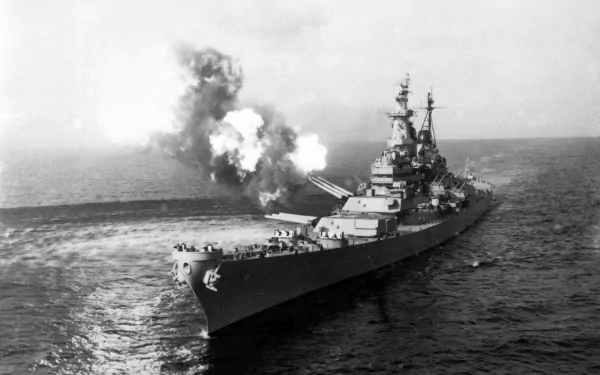 Black and white HD desktop wallpaper of the USS Missouri (BB-63) battleship firing its guns during military action at sea.