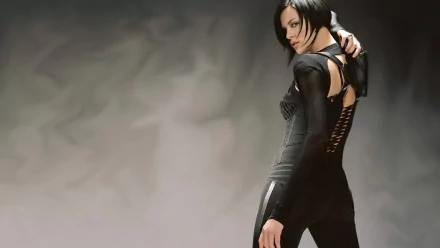 Charlize Theron in a striking pose from the movie Aeon Flux, showcasing her character's dynamic style in an atmospheric backdrop. HD wallpaper for a bold statement.