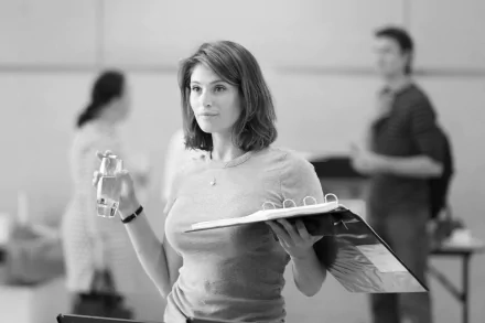 Black-and-white 4K Ultra HD wallpaper featuring Gemma Arterton from the movie Made in Dagenham, holding a binder and water bottle in a workplace setting.