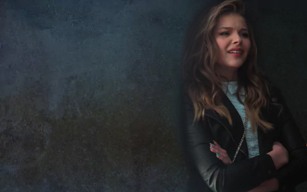 HD PC desktop wallpaper featuring celebrity Chloë Grace Moretz smiling with arms crossed against a dark textured background.