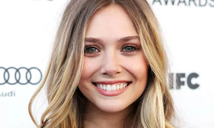 A radiant Elizabeth Olsen smiles for the camera at an event, showcasing her natural beauty. This HD image makes a stunning desktop wallpaper and background.