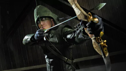 HD desktop wallpaper featuring Stephen Amell as Green Arrow from the TV show Arrow, aiming a bow and arrow while wearing a hooded green suit.