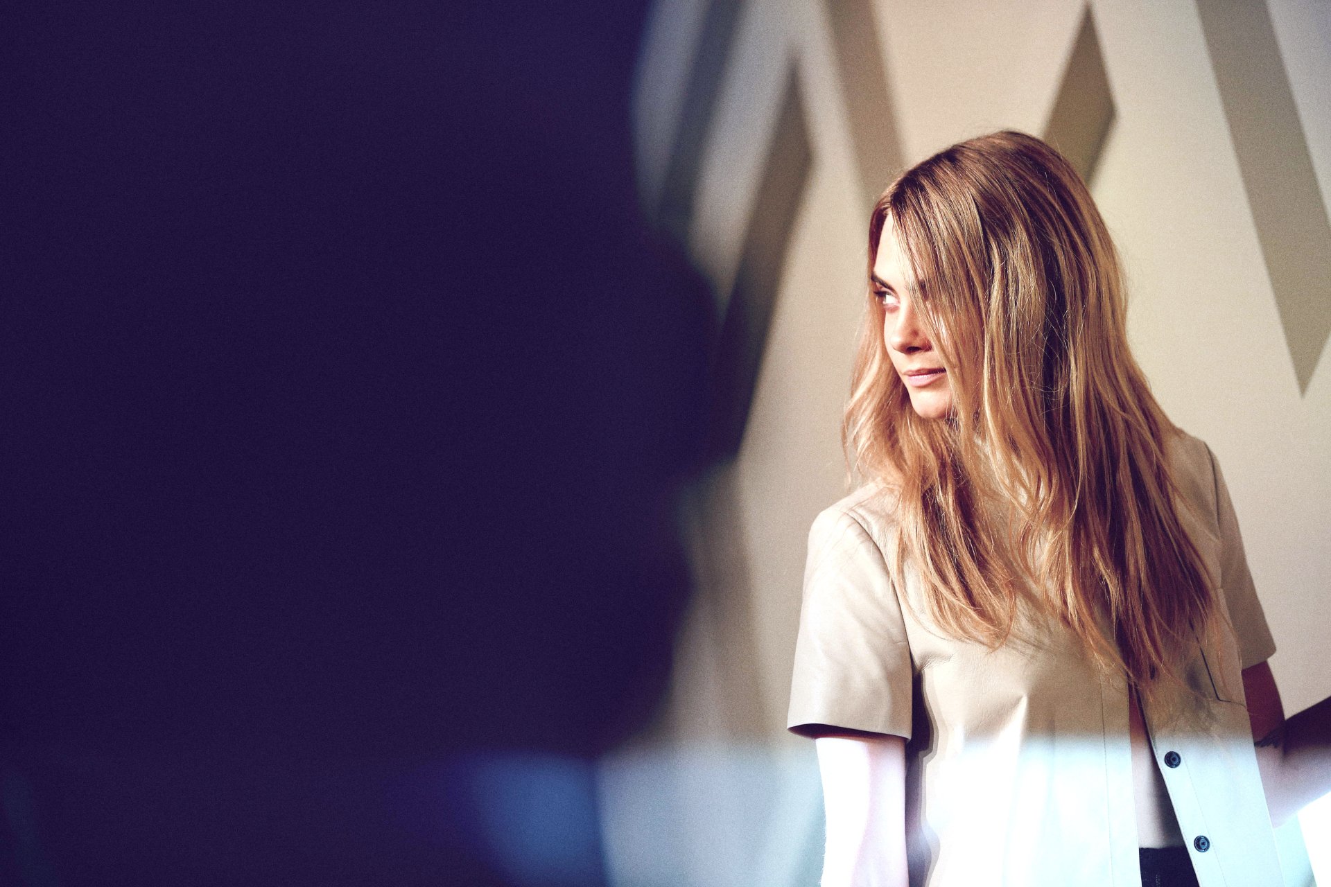 Blonde English model and actress posing thoughtfully in a soft-lit setting, captured in a high-resolution 4K Ultra HD desktop wallpaper background.