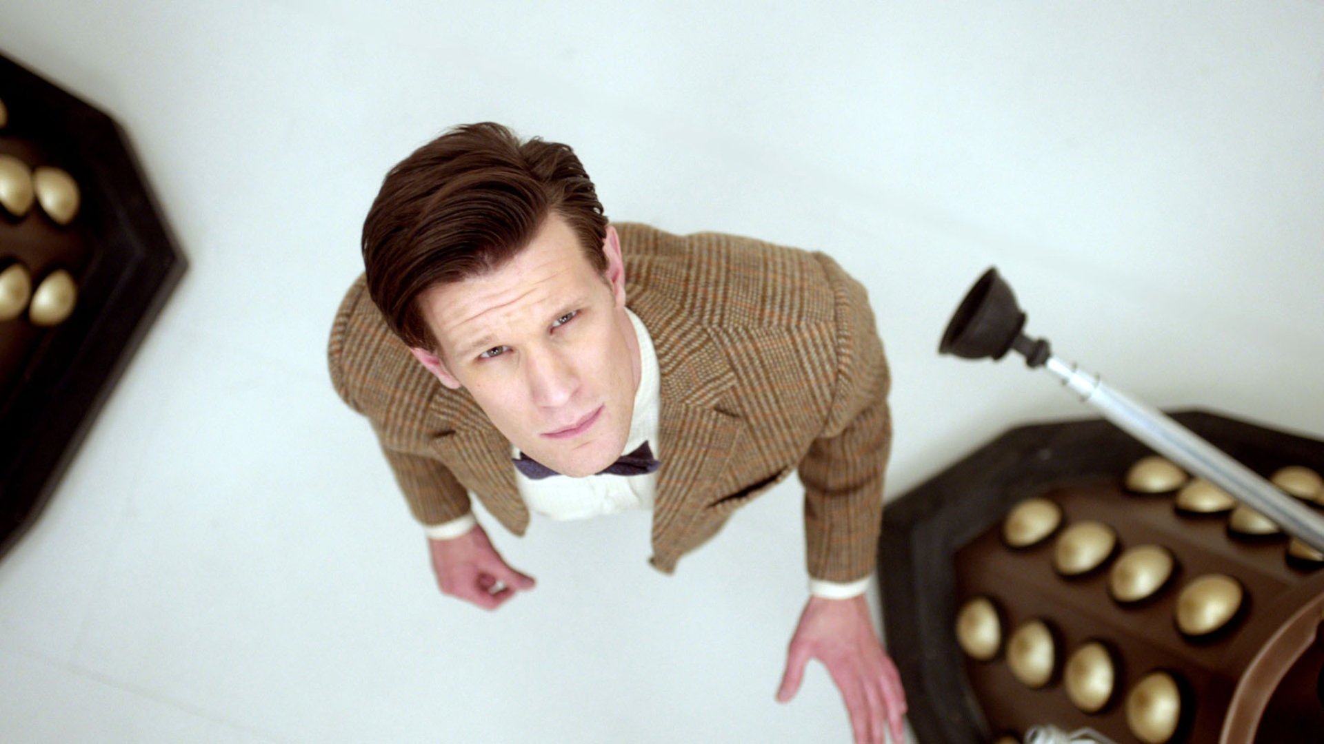 HD desktop wallpaper featuring the Eleventh Doctor from Doctor Who (2005), looking up with a Dalek partially visible beside him.