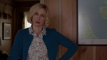 Vera Farmiga in a scene from the TV show Bates Motel, portrayed in a stylish and dramatic setting, featuring a wooden wall and a map in the background. HD PC desktop wallpaper.