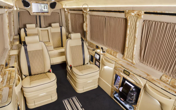 Interior of a Mercedes-Benz Sprinter van car vehicle: cream leather captain seats, wood trim, window curtains and ambient lighting, shown as an HD desktop wallpaper/background.