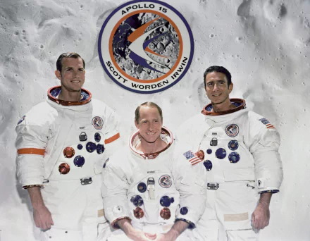 2K Quad HD desktop wallpaper showing three astronauts in Apollo-era NASA white spacesuits standing against a lunar surface backdrop with the Apollo 15 mission patch.