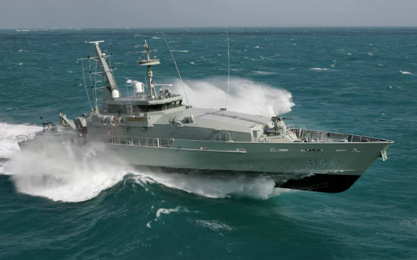 HD desktop wallpaper of the military patrol boat HMAS Larrakia (ACPB 84) cutting through ocean waves.
