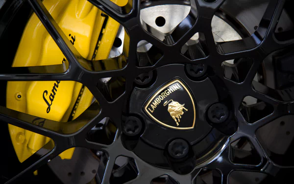 Close-up of a Lamborghini wheel featuring intricate black spokes and a golden logo, highlighting the vehicle's luxury and performance in stunning 4K Ultra HD quality.