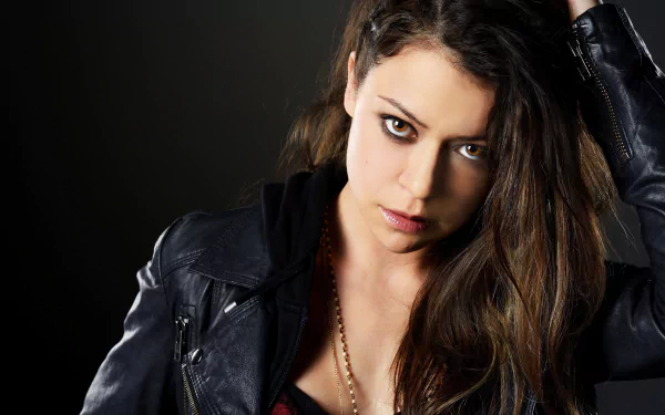 Close-up of a woman with intense eyes and long dark hair in a black leather jacket, featured in a 4K Ultra HD PC desktop wallpaper from the TV show Orphan Black.