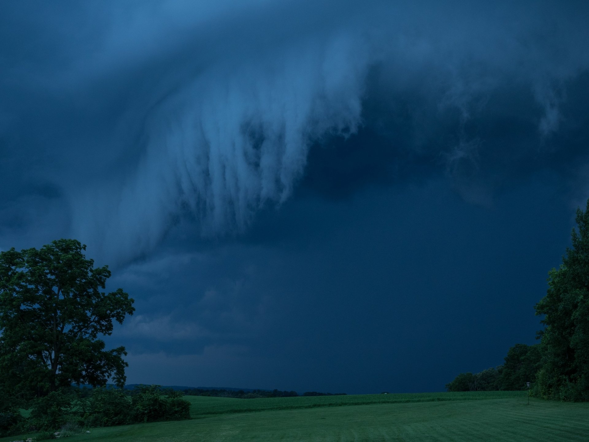 Dark storm clouds roll over a landscape at night, captured in a 4K Ultra HD nature scene for a PC desktop wallpaper.