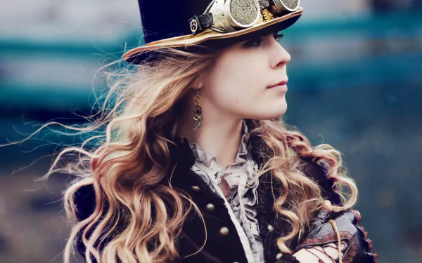 A steampunk-inspired woman with long, flowing hair wears a stylish top hat and goggles, set against a blurred background, creating an intriguing sci-fi atmosphere in this HD wallpaper.