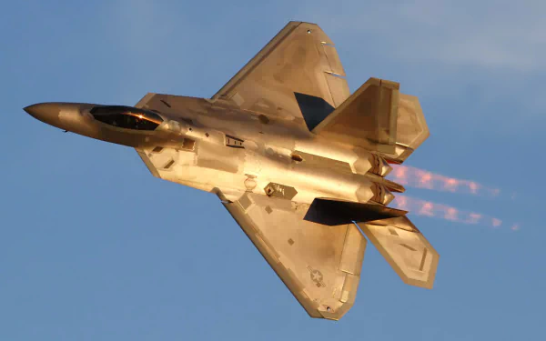 HD wallpaper featuring a Lockheed Martin F-22 Raptor jet fighter, showcasing its sleek design and powerful afterburners against a clear blue sky.
