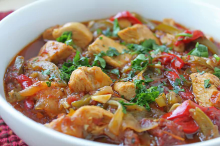Close-up food shot of a hearty vegetable and chicken stew garnished with fresh herbs in rich tomato broth — 4K Ultra HD PC desktop wallpaper background.