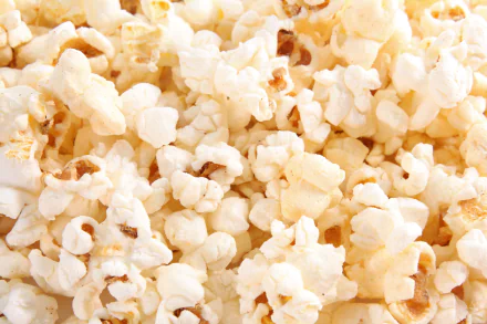 HD PC desktop wallpaper and background showing a close-up of buttery popcorn (food), kernels filling the frame with warm, textured detail.