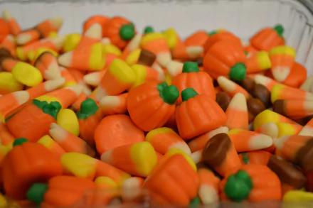 4K Ultra HD PC desktop wallpaper: close-up of food — candy corn and pumpkin-shaped candies in bright orange, yellow and white.
