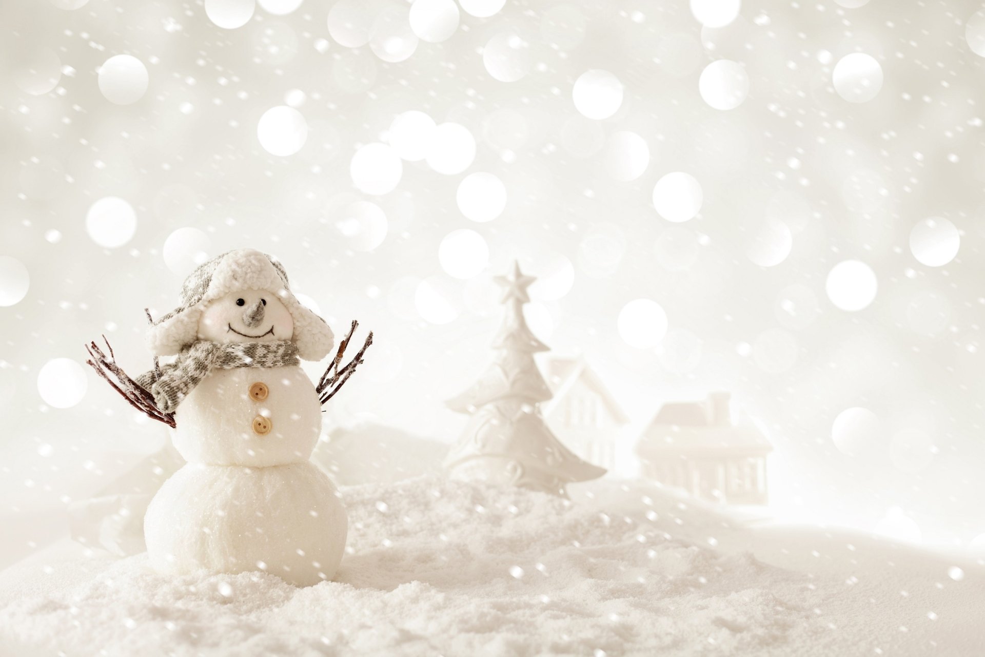 HD desktop wallpaper featuring an artistic white snowman with twig arms, a Christmas tree, and a snowy Christmas scene in soft focus.