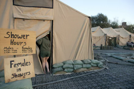 A soldier enters a shower tent, with signs indicating designated shower hours for males and females, set against a backdrop of military tents and surroundings. 4K Ultra HD wallpaper.