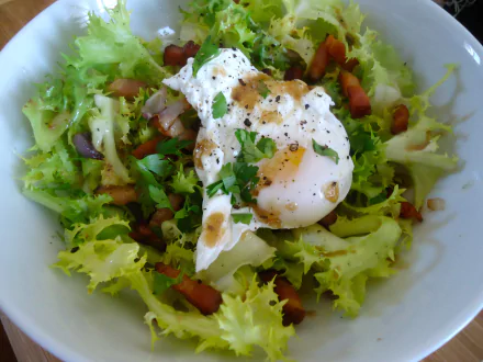 Salade Lyonnaise lunch: frisée lettuce with lardons and a soft-poached egg, drizzled dressing — vibrant 4K Ultra HD PC desktop wallpaper of a meal