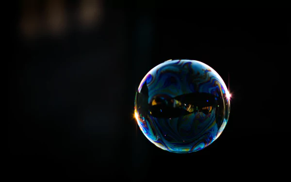 Photography of a single luminous soap bubble on a dark background — 4K Ultra HD PC desktop wallpaper/background, colorful reflections and a bright star-like glint.
