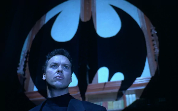 HD PC desktop wallpaper: an actor as Batman stands beneath a giant bat emblem, scene from the movie Batman Returns.