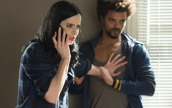 4K Ultra HD PC desktop wallpaper — moody Jessica Jones TV show scene: female lead on phone as a man presses against a wall, tense posture and dramatic window light.