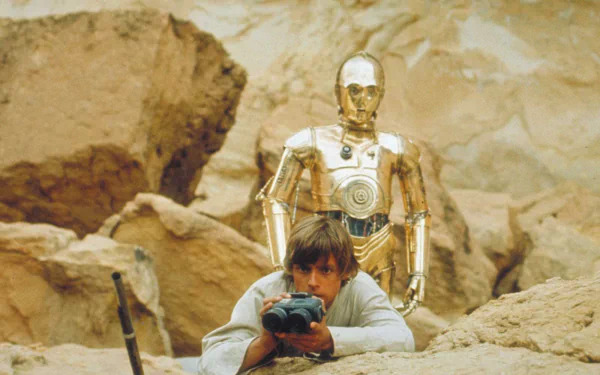 Luke Skywalker crouches with a camera while C-3PO stands behind him amidst a rocky desert landscape in a scene from Star Wars Episode IV: A New Hope. HD wallpaper.