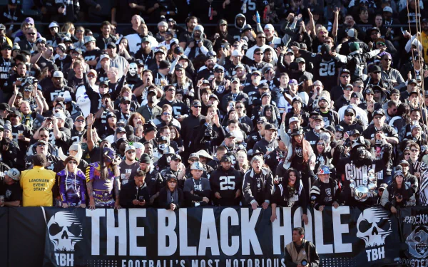 HD desktop wallpaper featuring a packed crowd of Las Vegas Raiders fans dressed in team colors, creating an intense and energetic sports atmosphere.