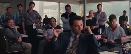HD PC wallpaper: trading-floor scene from the movie The Wolf of Wall Street — lead broker on the phone, gesturing to colleagues in a bustling office.