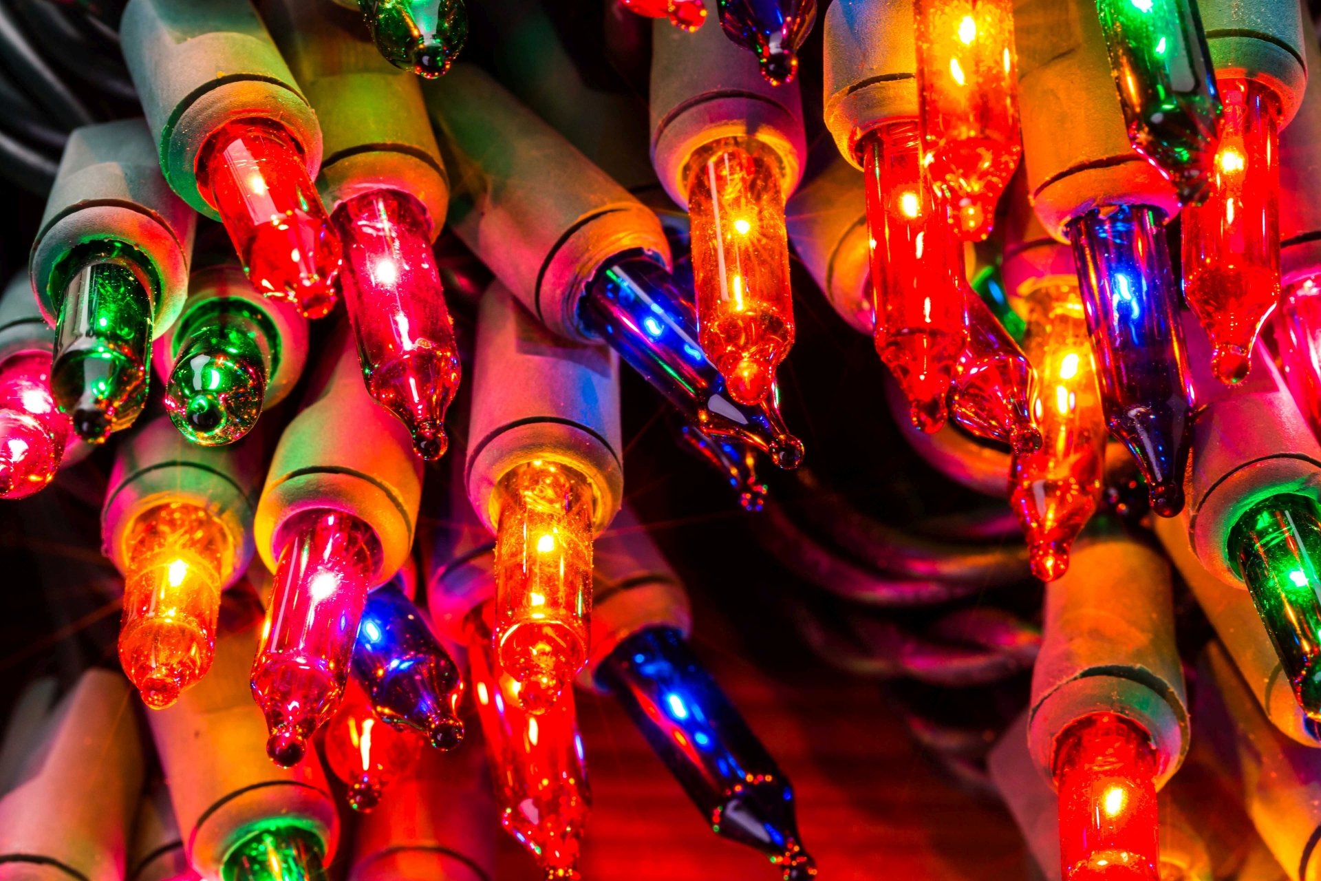 Close-up of colorful Christmas string lights aglow, festive holiday glow and bokeh — 5K Ultra HD PC desktop wallpaper/background.