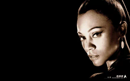 Zoe Saldana in a striking pose, featured in an HD background inspired by her role in Star Trek. The image highlights her captivating presence and fierce character.