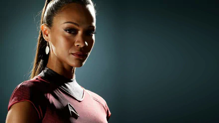 Zoe Saldana as Nyota Uhura in Star Trek, depicted in a striking pose with a dark background, creating a captivating HD desktop wallpaper.
