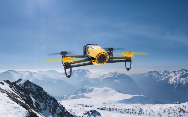 A sleek drone soars over snow-capped mountains under a clear blue sky, showcasing a stunning blend of technology and nature in this 4K Ultra HD wallpaper.