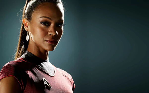 Zoe Saldana as Nyota Uhura in Star Trek, depicted in a striking pose with a dark background, creating a captivating HD desktop wallpaper.