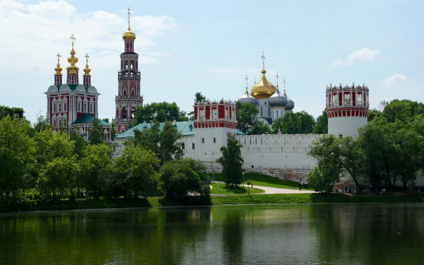 A stunning 4K Ultra HD image of Moscow’s historic man-made buildings, featuring ornate architecture reflected in a calm river under a clear sky.