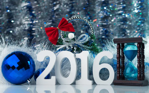 A festive scene featuring the year 2016 in white, adorned with a red ribbon, a blue ornament, and an hourglass, all set against a shimmering holiday background.