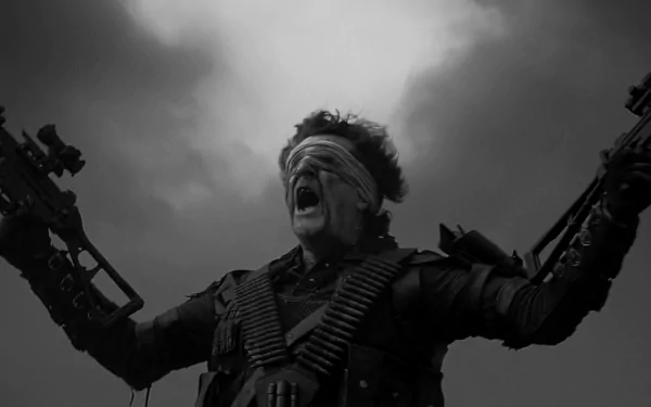 HD PC desktop wallpaper from Mad Max: Fury Road: a blindfolded, armored man screams with arms raised, ammo belts across his chest against a brooding, stormy sky background.
