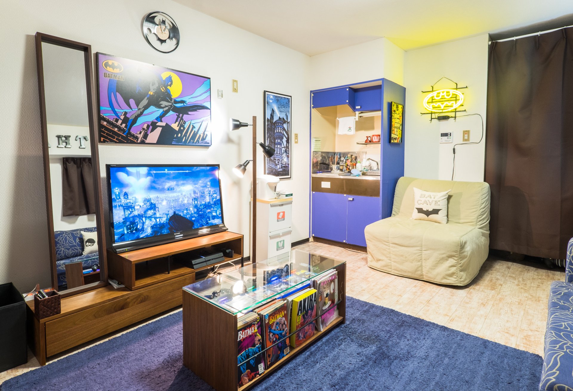 HD PC desktop wallpaper showing a cozy room with a Batman-themed television, coffee table, and a comfortable chair, blending modern decor with superhero elements.