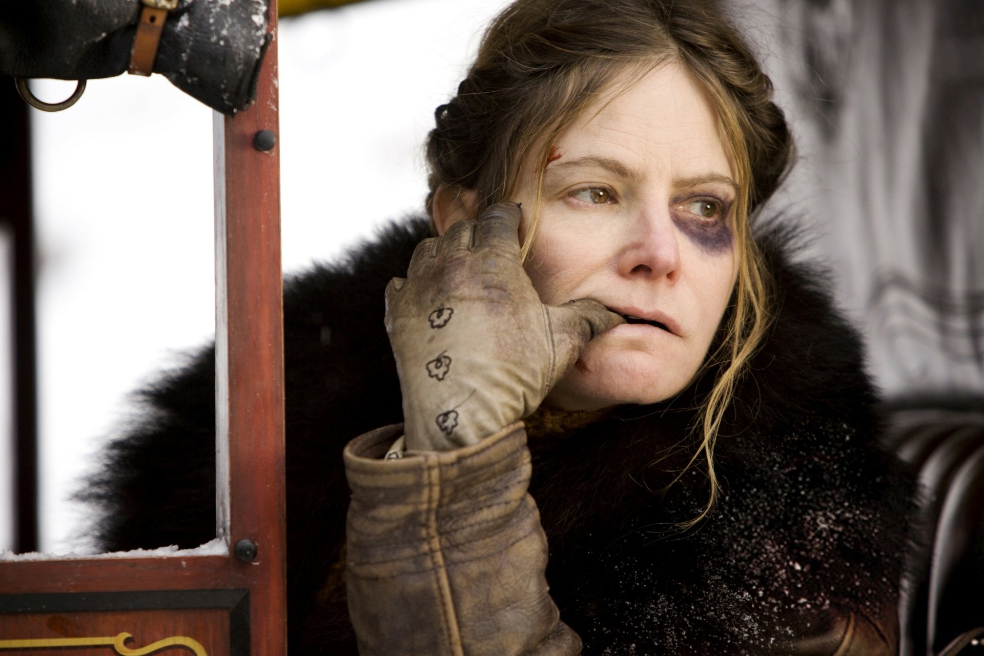 HD desktop wallpaper featuring Jennifer Jason Leigh in character from the movie The Hateful Eight, showcasing a weathered and intense look.