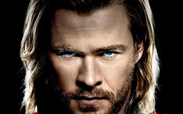 Close-up of Chris Hemsworth as Thor, showcasing his intense gaze and iconic long hair. This HD desktop wallpaper captures the powerful essence of the character from the movie.