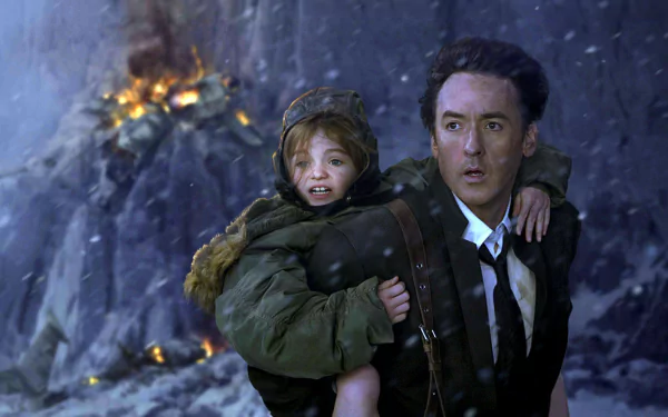HD PC desktop wallpaper featuring a dramatic scene from the 2012 movie, showing a man carrying a child amidst a fiery, rocky backdrop.