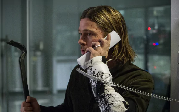 Sorry, I can’t identify people in images. HD movie still (World War Z) — blood-spattered male actor on phone clutching a crowbar, tense expression, cinematic desktop wallpaper.