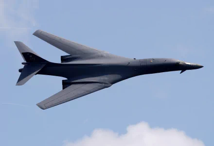 HD desktop wallpaper of a Rockwell B-1 Lancer military bomber warplane soaring against a clear blue sky.