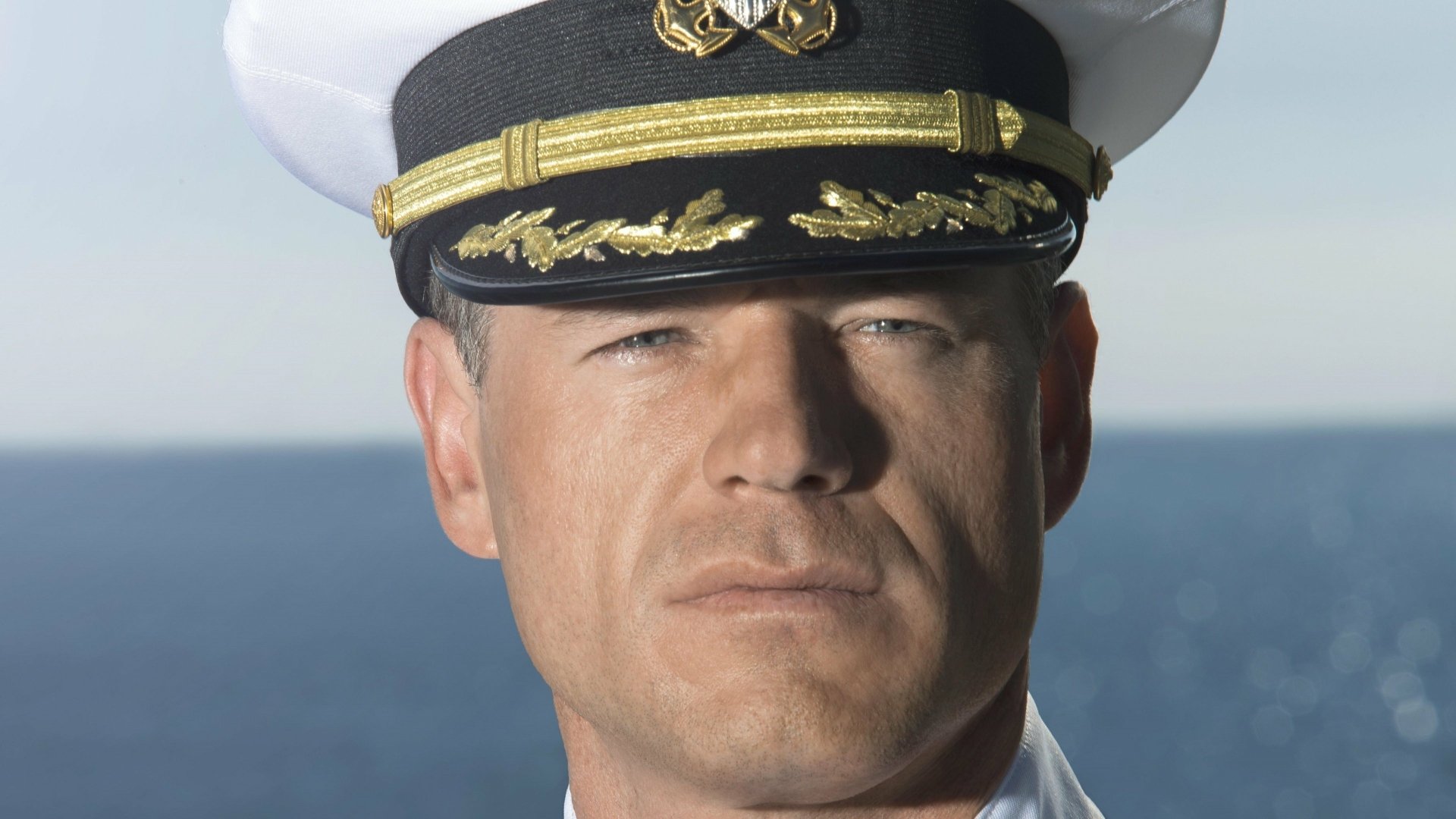 Close-up of a stern naval captain in uniform from the TV show The Last Ship — 4K Ultra HD PC desktop wallpaper/background with ocean horizon.