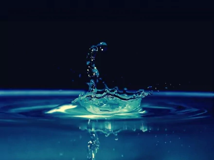 A high-definition desktop wallpaper showcasing a stunning water drop with a dark background, capturing the beauty of nature's simplicity.