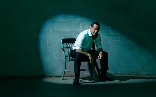 2K Quad HD desktop wallpaper of a TV show agent seated under a harsh spotlight in a dim, moody interrogation-style room.