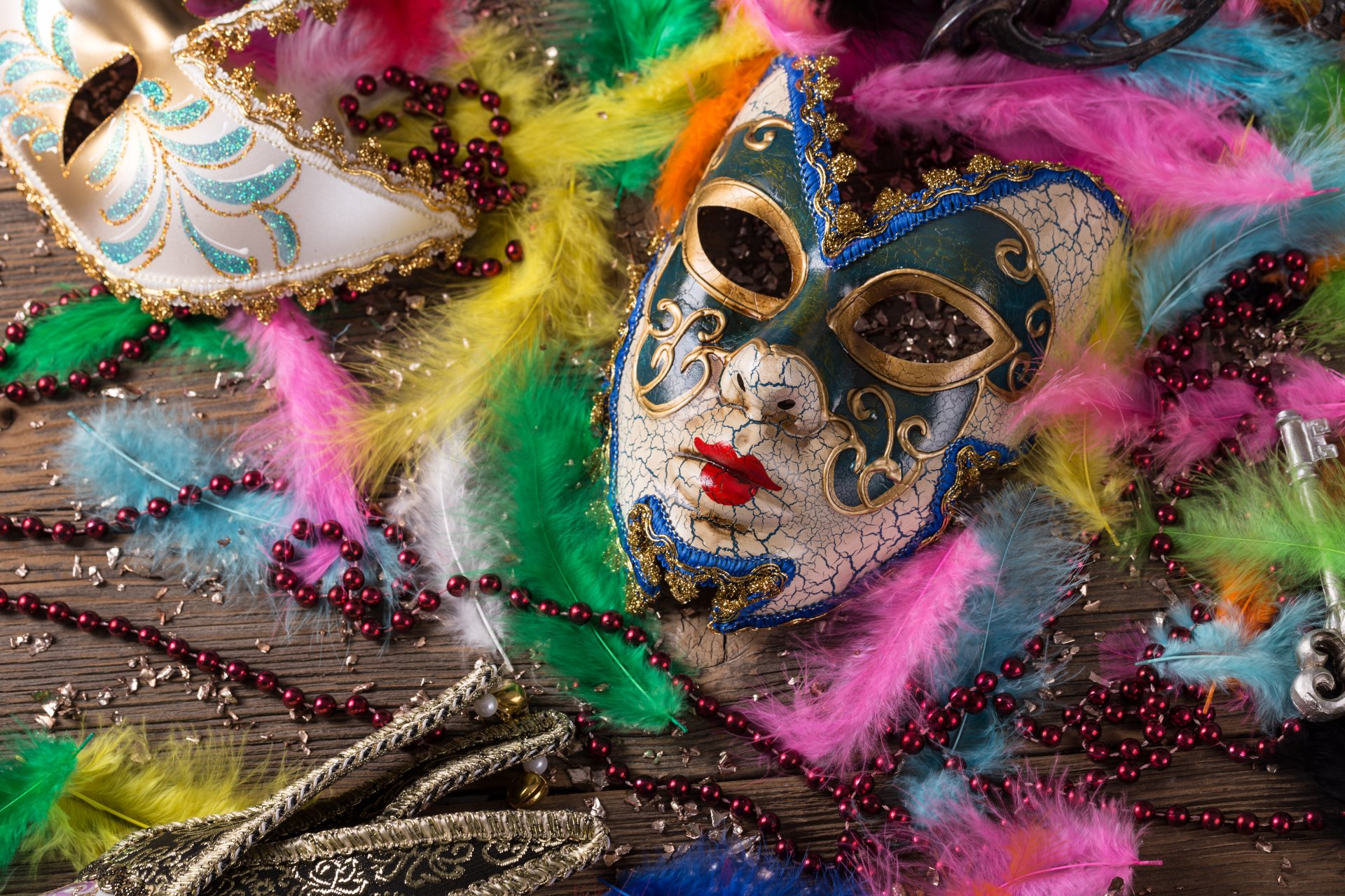 Colorful feathers and intricate masks are artfully arranged in this vibrant carnival-themed 4K Ultra HD wallpaper, capturing the festive spirit of celebration.