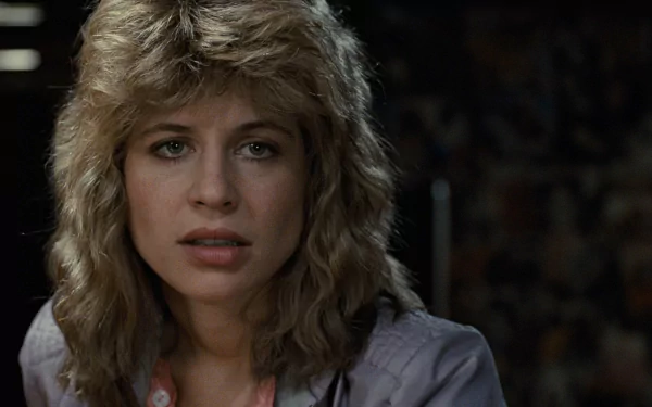 A close-up of Linda Hamilton as Sarah Connor from the movie The Terminator, showcasing her determined expression in a dramatic scene. High-definition wallpaper for fans of the film.