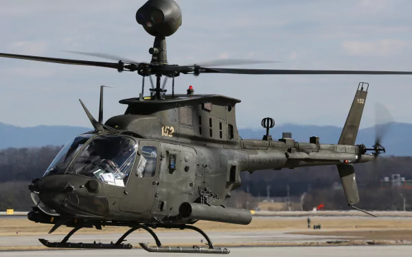 Military Bell OH-58 Kiowa helicopter on the ground with clear sky, captured as an HD PC desktop wallpaper background.