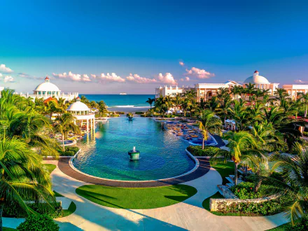 Tropical Turks and Caicos resort with palm trees, a large man-made pool, and elegant buildings under a clear blue sky, captured in HD for a PC desktop wallpaper.